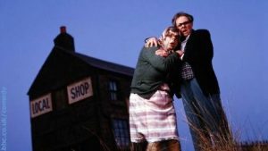 Two figures in front of local shop from BBC Archives